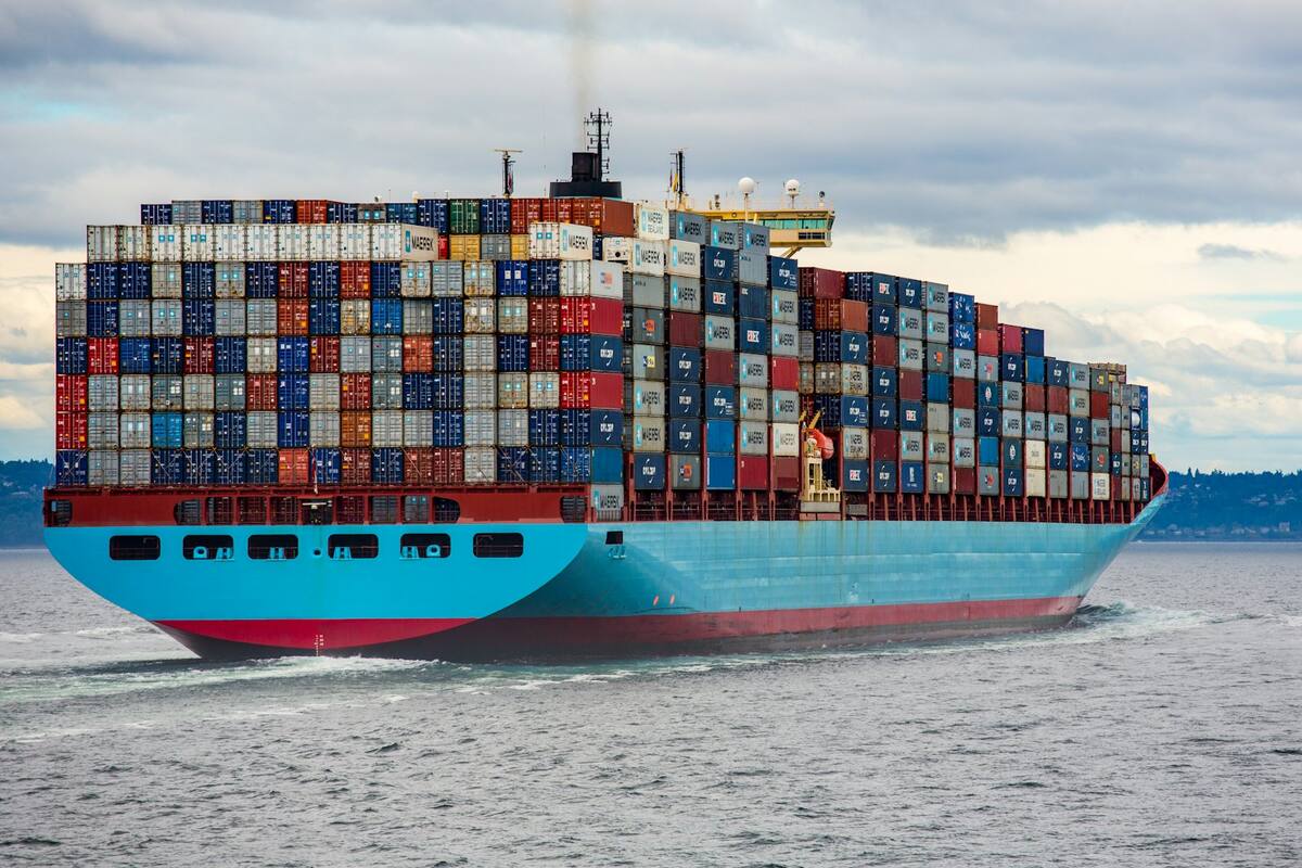 Stacked shipping containers on a quayside at dusk